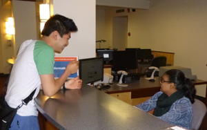 Student employee Elaine greeting Wallace Library visitors at the Circulation Desk