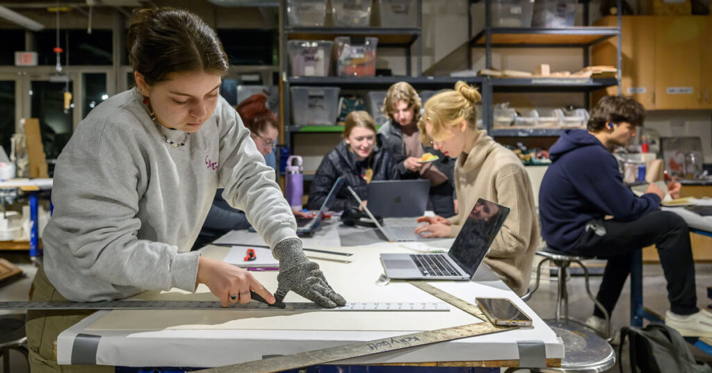 Students working on architectural drafting tables.